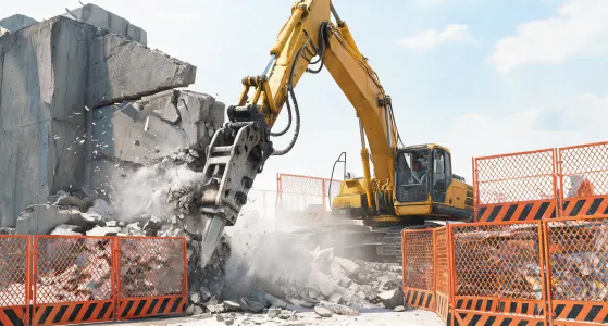 Excavator with hydraulic hammer on demolition site